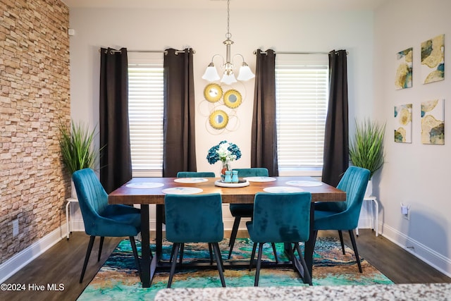 dining area with dark hardwood / wood-style flooring and a chandelier