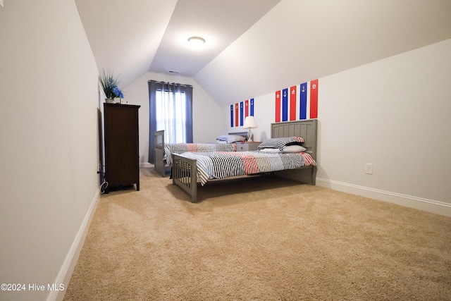 bedroom with light carpet and lofted ceiling