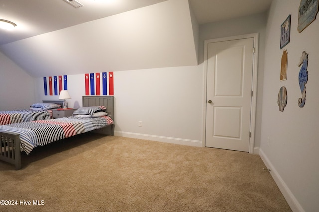 carpeted bedroom with lofted ceiling