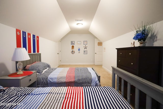 bedroom with light colored carpet and lofted ceiling