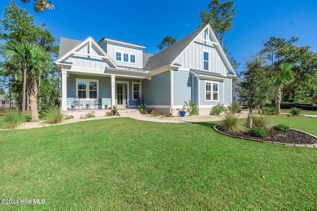 view of front facade featuring metal roof, board and batten siding, a front yard, and a standing seam roof