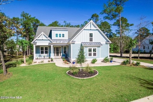 modern farmhouse style home featuring a standing seam roof, a front lawn, board and batten siding, and roof with shingles