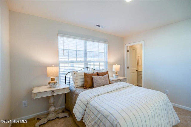 carpeted bedroom featuring ensuite bath