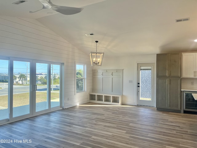 interior space with hardwood / wood-style floors, wine cooler, high vaulted ceiling, and wooden walls