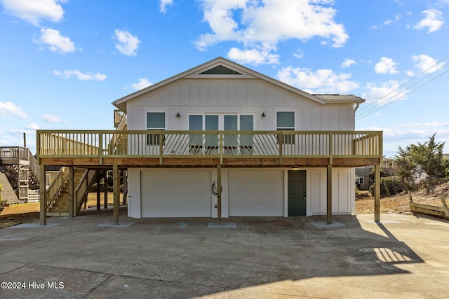 rear view of property featuring a garage and a deck