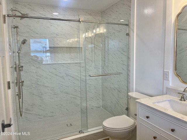 bathroom featuring walk in shower, vanity, and toilet