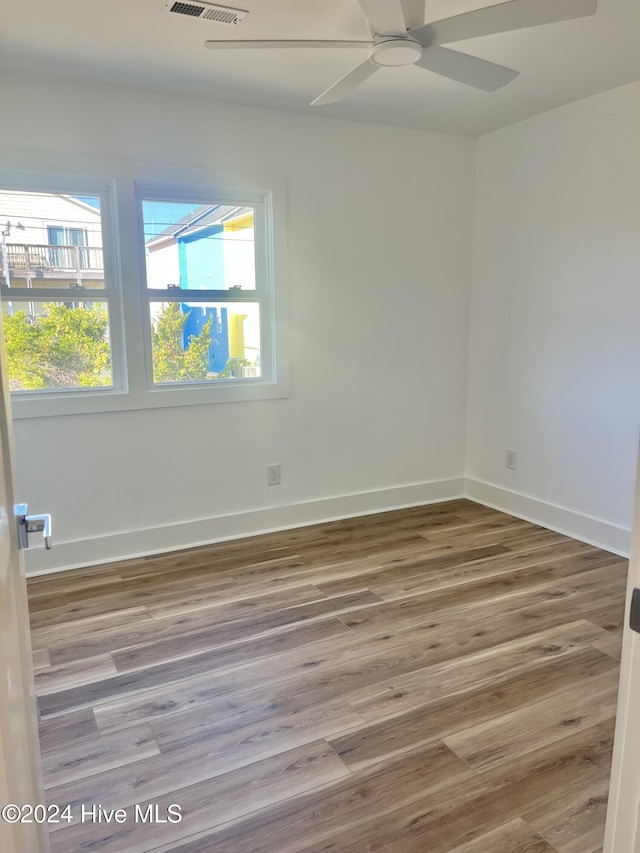 unfurnished room with hardwood / wood-style flooring and ceiling fan