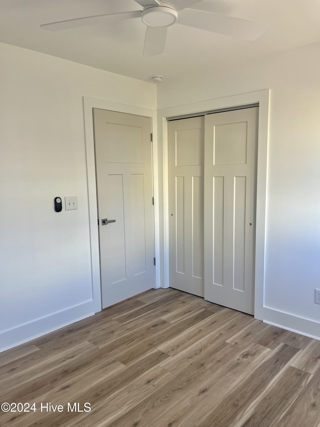 unfurnished bedroom with ceiling fan, a closet, and light hardwood / wood-style flooring