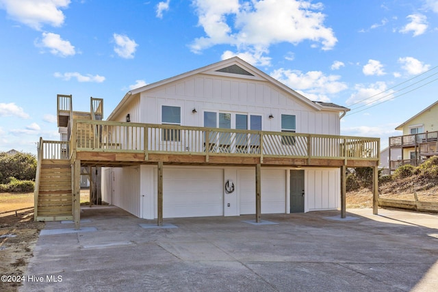 back of house featuring a garage and a wooden deck