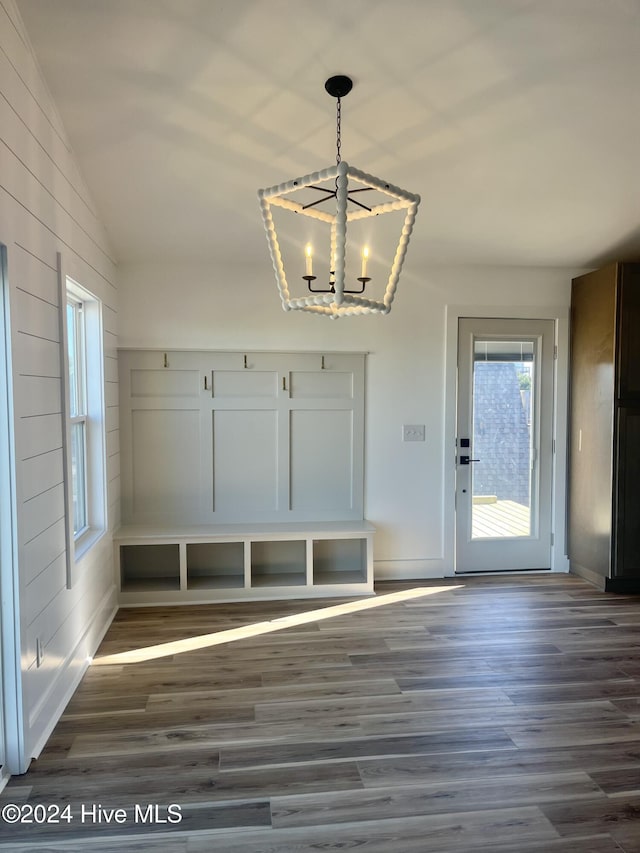 mudroom with dark wood-type flooring, lofted ceiling, and an inviting chandelier