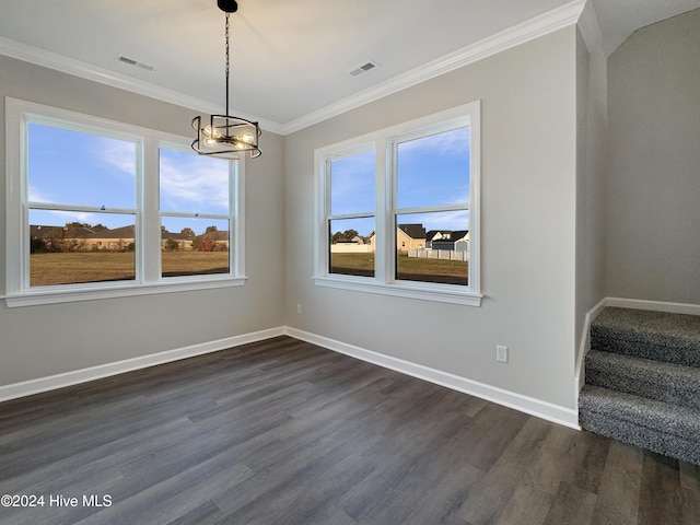 spare room featuring crown molding, dark hardwood / wood-style floors, and a notable chandelier