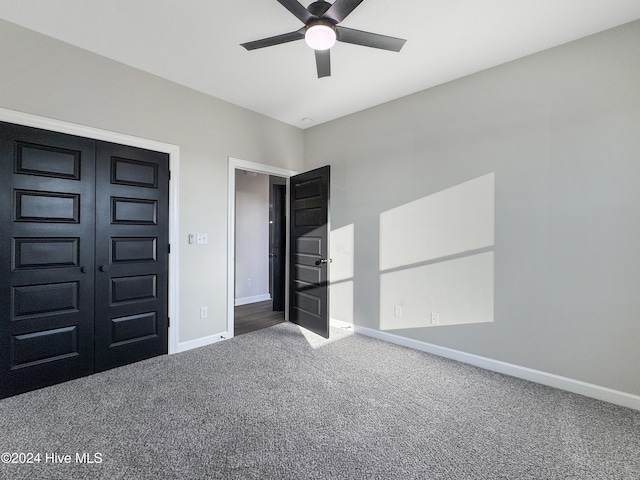 unfurnished bedroom with ceiling fan, a closet, and carpet