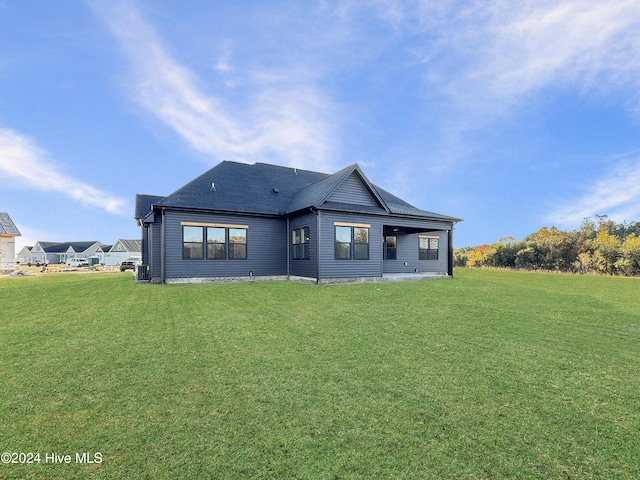 rear view of house featuring a lawn