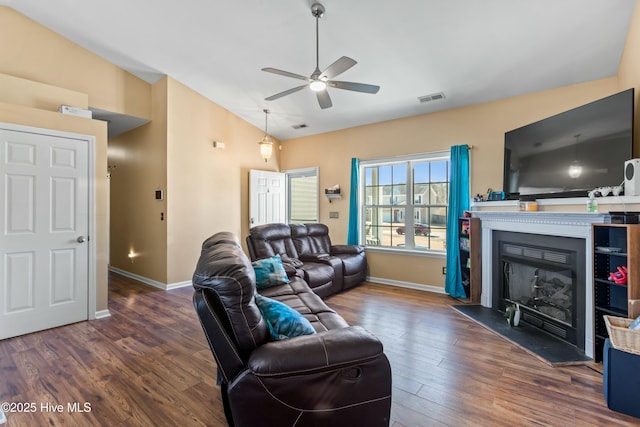 living room featuring lofted ceiling, dark wood-type flooring, and ceiling fan