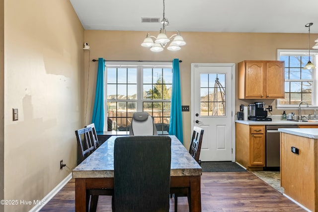 dining area with an inviting chandelier, dark hardwood / wood-style flooring, and sink