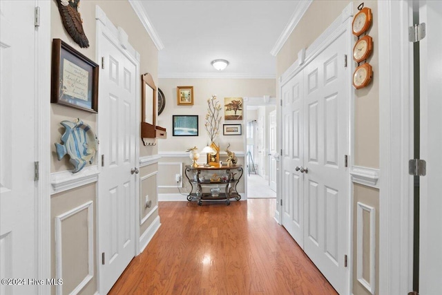 hallway with hardwood / wood-style flooring and crown molding