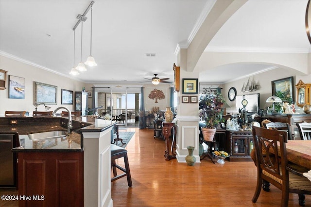 kitchen with dishwasher, sink, hanging light fixtures, ceiling fan, and a breakfast bar area