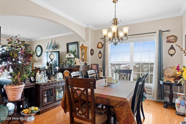 dining space with a chandelier, light hardwood / wood-style flooring, and crown molding