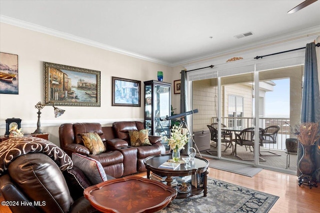 living room featuring wood-type flooring and crown molding