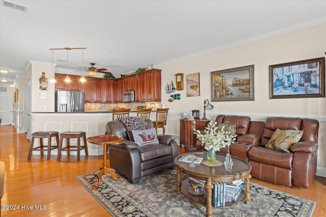 living room with ceiling fan, light hardwood / wood-style flooring, track lighting, and ornamental molding