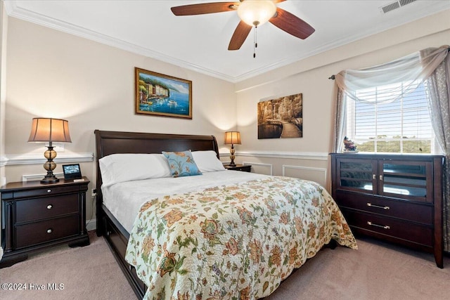 carpeted bedroom with ceiling fan and crown molding