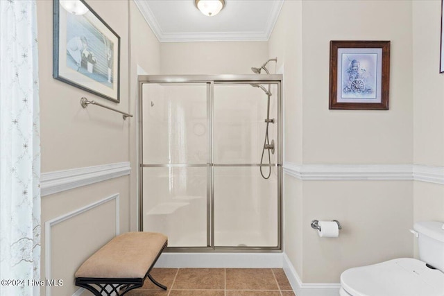 bathroom featuring tile patterned flooring, toilet, ornamental molding, and walk in shower