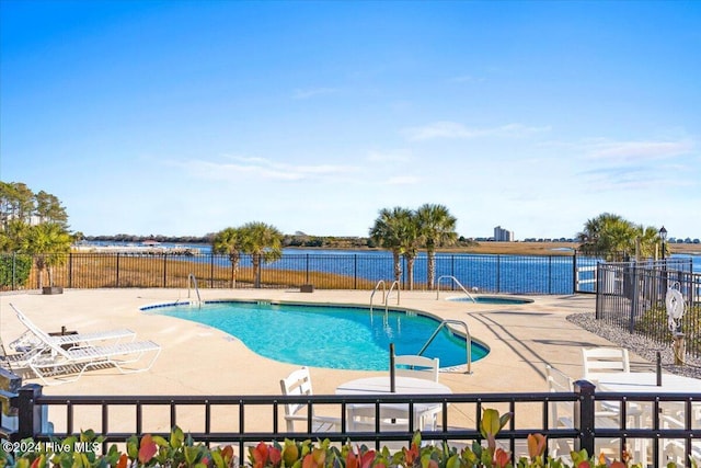 view of pool featuring a water view and a patio