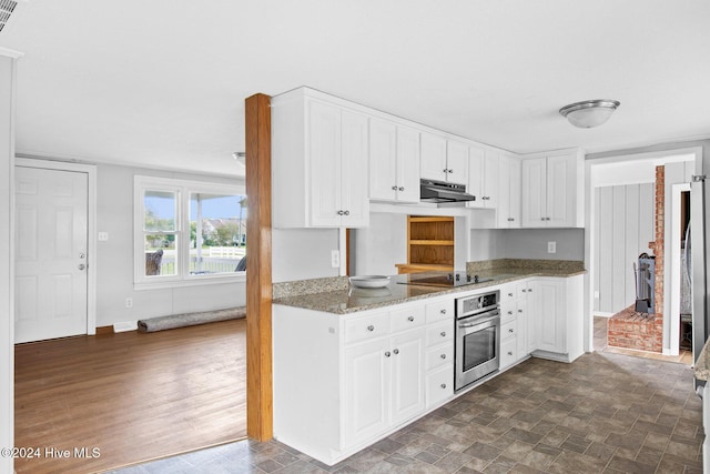 kitchen featuring white cabinetry, stainless steel oven, dark wood-type flooring, dark stone countertops, and black electric stovetop