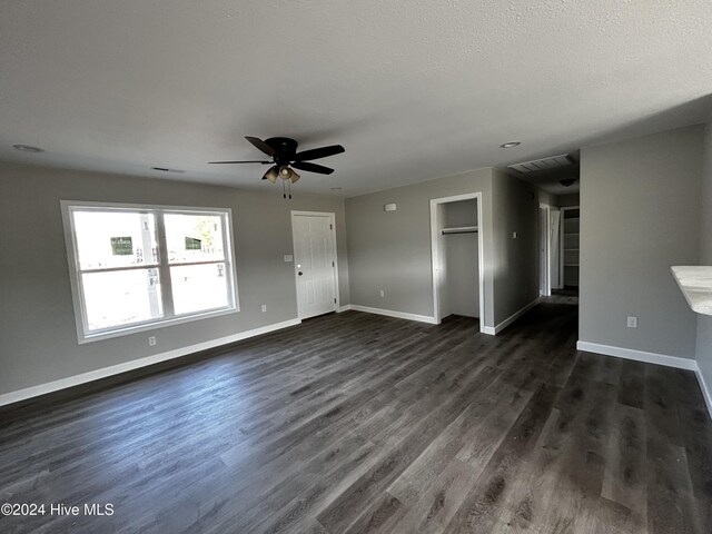 unfurnished living room featuring dark hardwood / wood-style flooring and ceiling fan