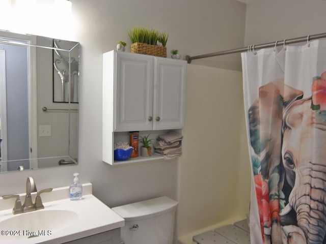 bathroom with toilet, vanity, and walk in shower