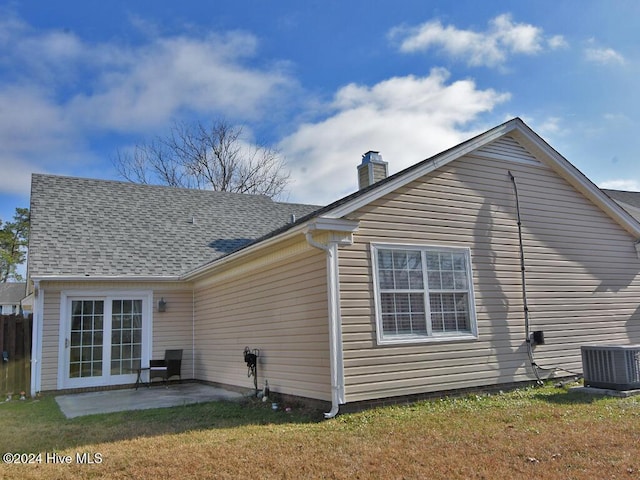 rear view of house with a lawn, central air condition unit, and a patio