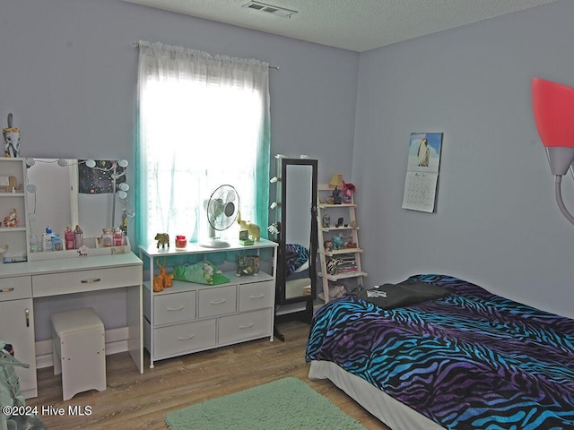 bedroom featuring wood-type flooring and a textured ceiling