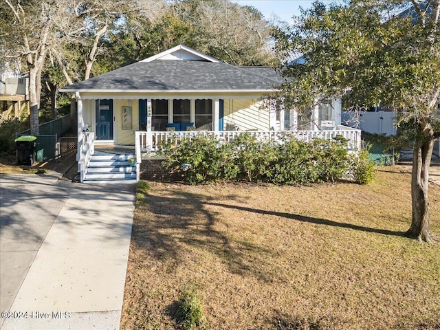 bungalow with covered porch and a front yard