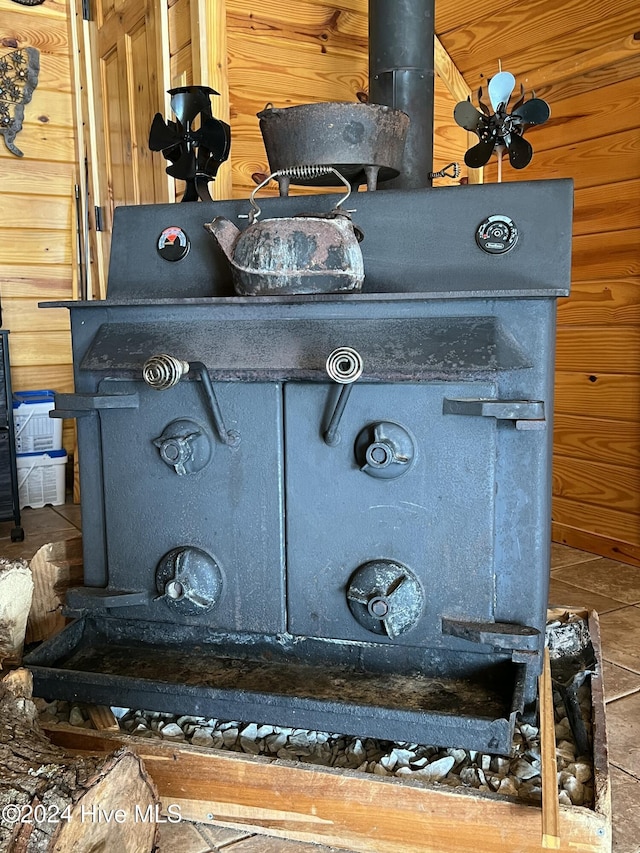 interior details featuring a wood stove and wooden walls