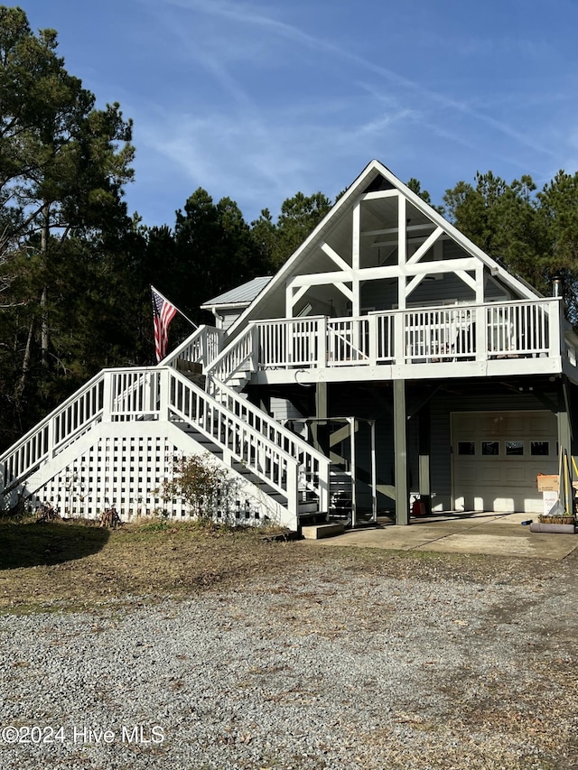 back of property with a wooden deck and a garage