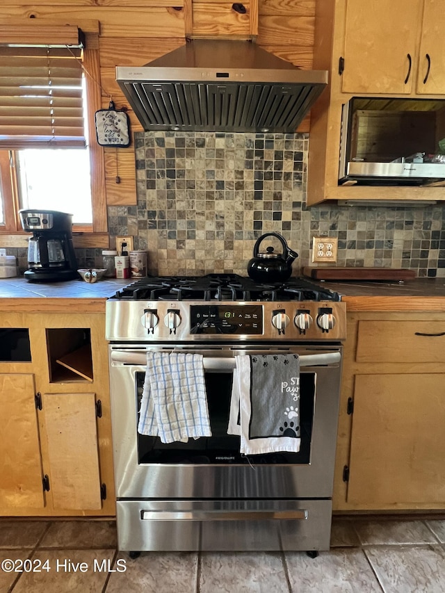 kitchen with island exhaust hood, gas stove, and decorative backsplash