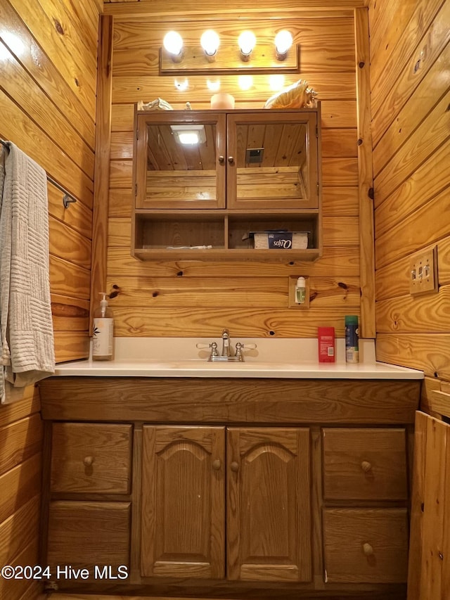 bathroom featuring vanity and wood walls