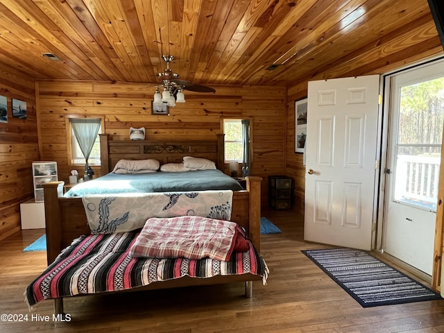 bedroom featuring wood ceiling, wooden walls, and light wood-type flooring