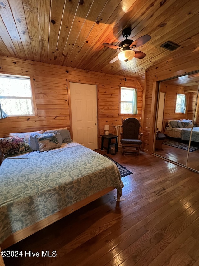 bedroom featuring dark wood-type flooring, wood walls, and wooden ceiling