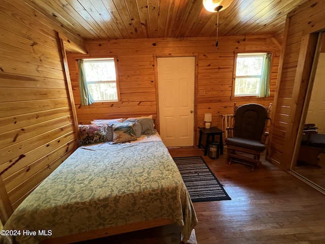 bedroom with dark wood-type flooring, wood ceiling, and wood walls