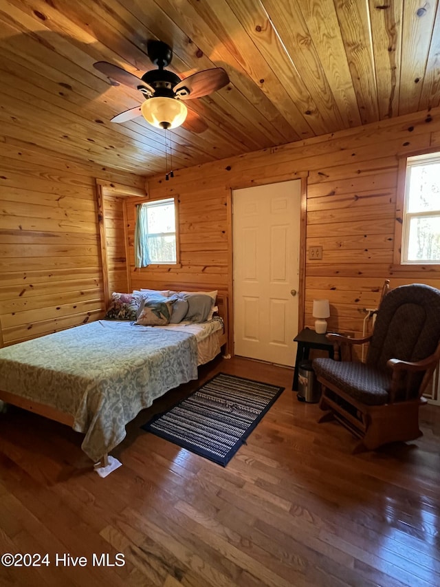 bedroom with wood-type flooring, wooden ceiling, and wood walls