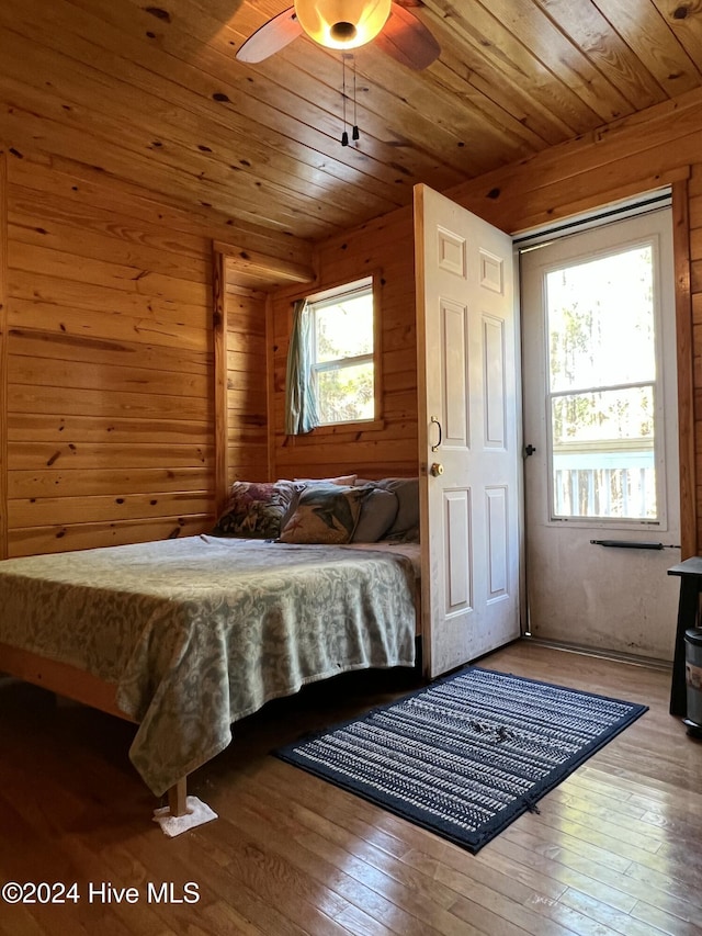 bedroom with hardwood / wood-style flooring, wooden walls, and wooden ceiling