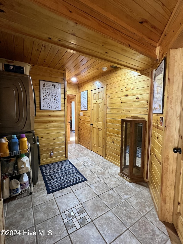 entryway with wood ceiling, wooden walls, washer / dryer, and light tile patterned floors