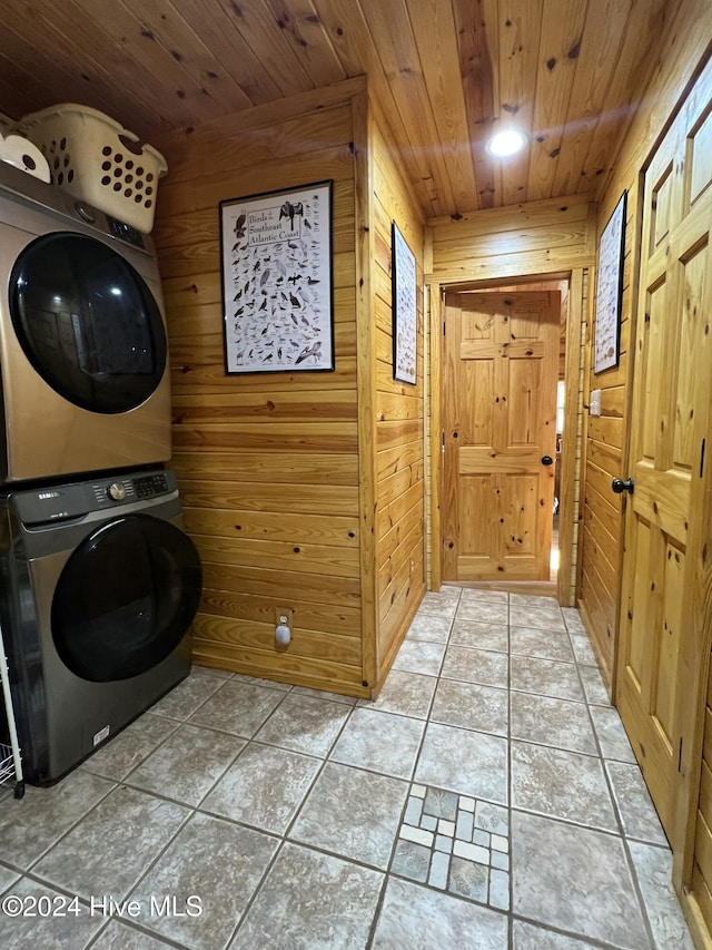 washroom featuring tile patterned flooring, wooden walls, wooden ceiling, and stacked washer / dryer