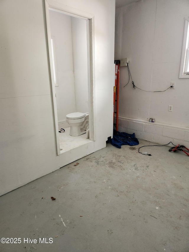 bathroom featuring concrete floors and toilet