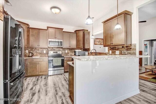 kitchen with kitchen peninsula, appliances with stainless steel finishes, and a kitchen breakfast bar