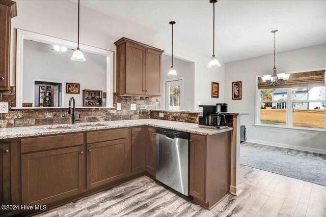 kitchen featuring dishwasher, kitchen peninsula, hanging light fixtures, and sink