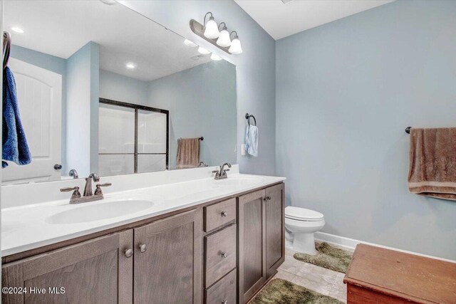 bathroom with vanity, toilet, a shower with shower door, and wood-type flooring