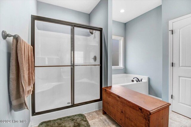 bathroom featuring independent shower and bath