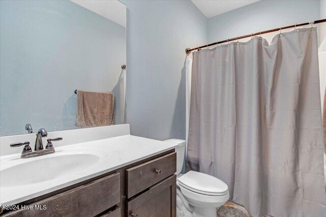 bathroom with vanity, a shower with shower curtain, and toilet